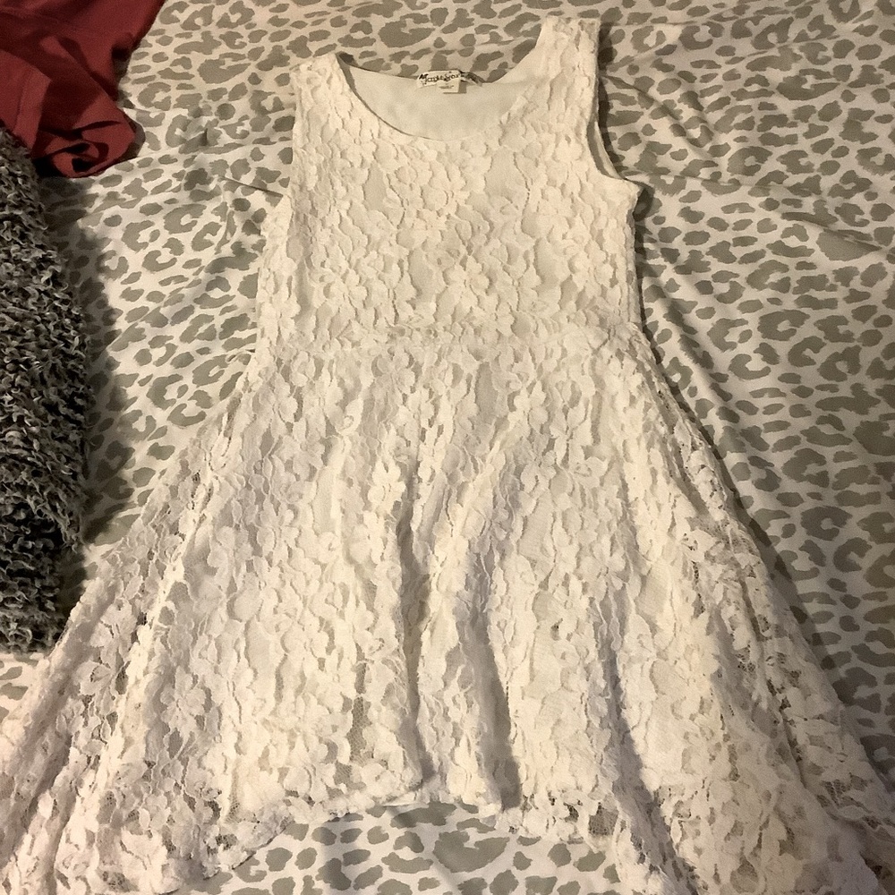 This is a white dress with with a flowered lace and a white covering bottom.